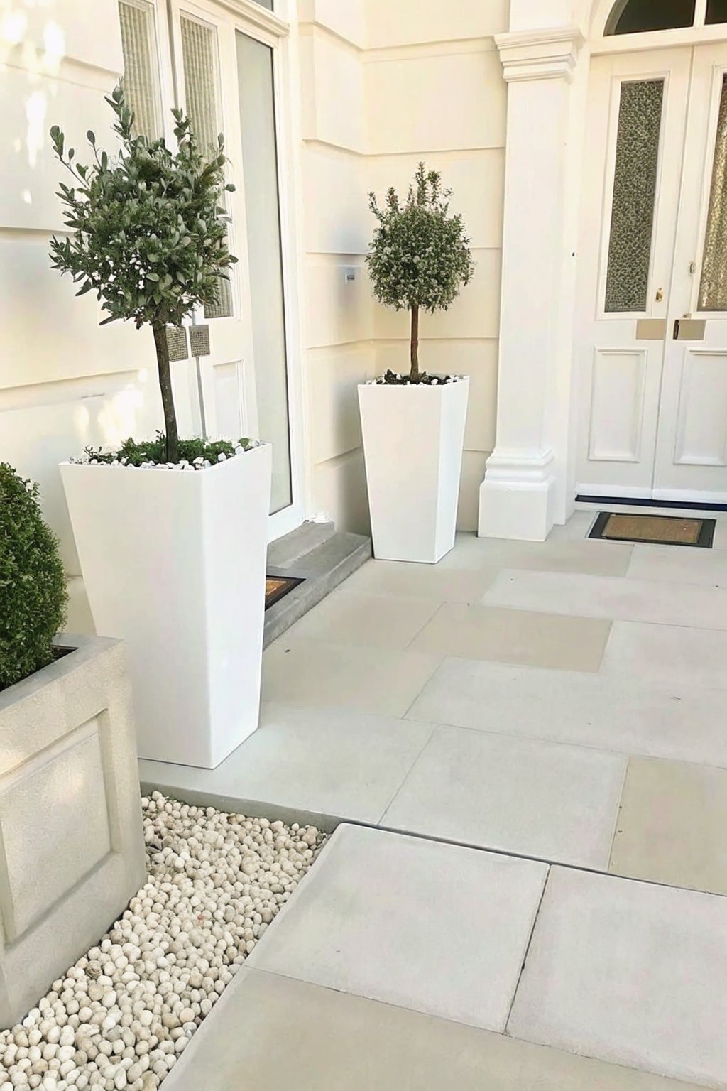 White square planters with topiary trees at elegant house entrance doorway