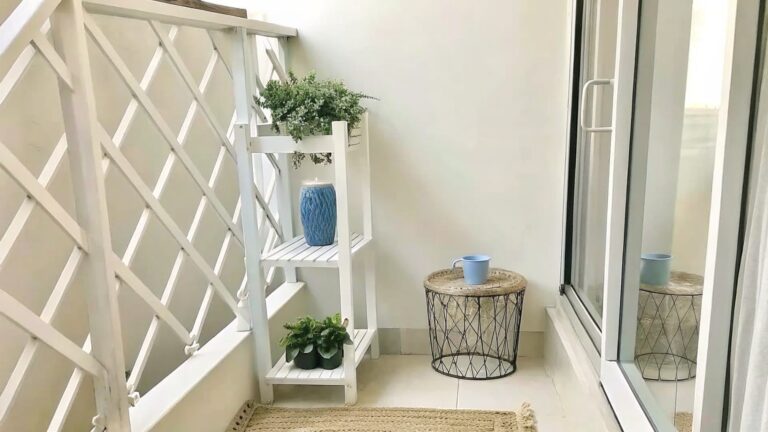 20 Beautiful Garden Pot Decor Ideas That Create Layered Container Focal Points White ladder with hanging plants beside blue mug on small round table and lace rug.
