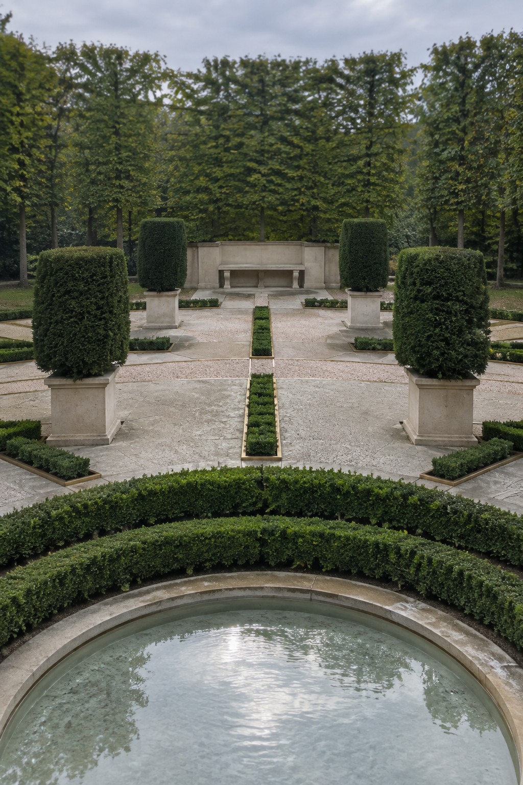 A formal garden view showing a central stone path lined with large potted clipped evergreens leading to a stone bench, with a circular pond edged by hedges in the foreground.