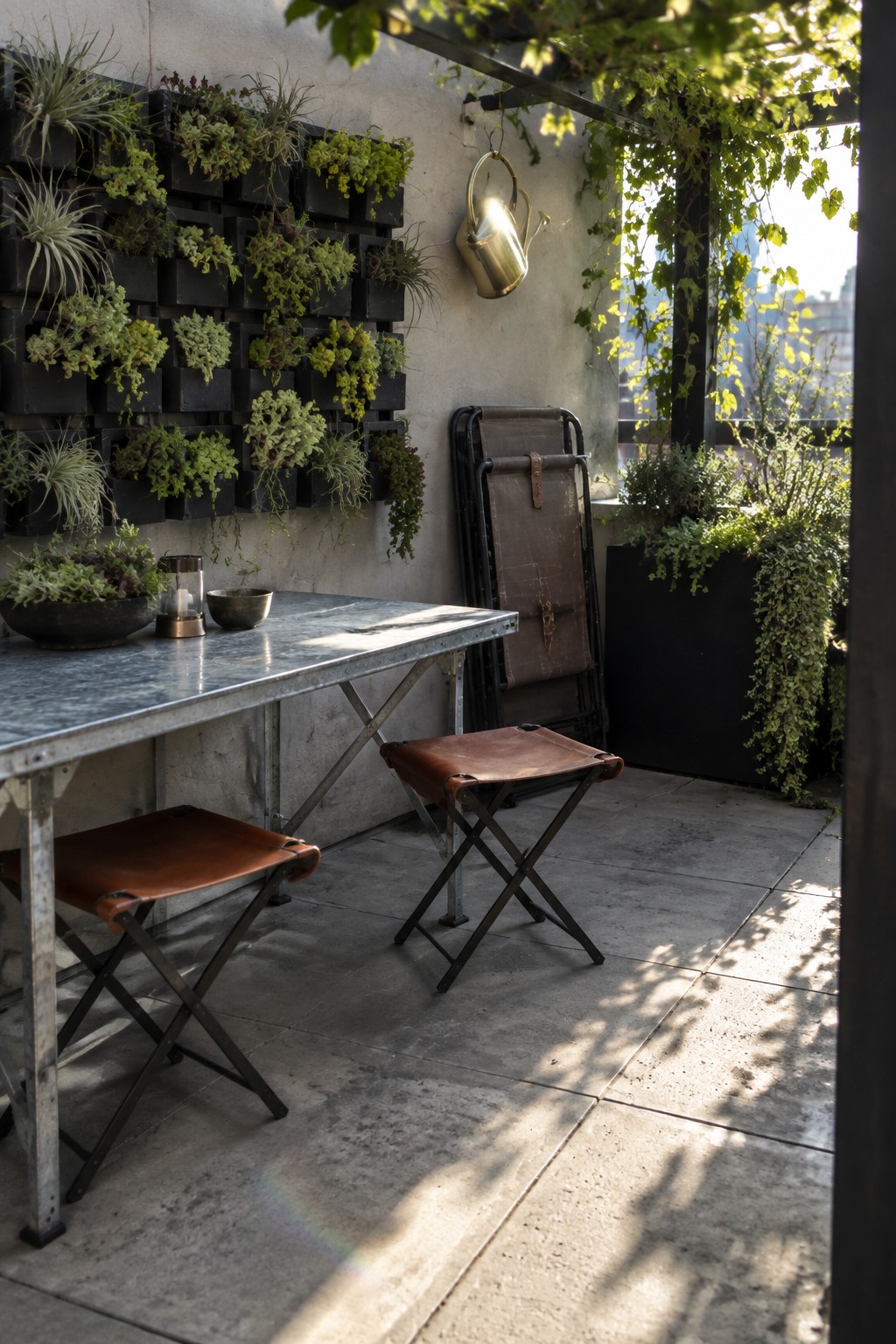 Sunlit patio with metal table, leather stools, vertical plant wall, and folded chair.