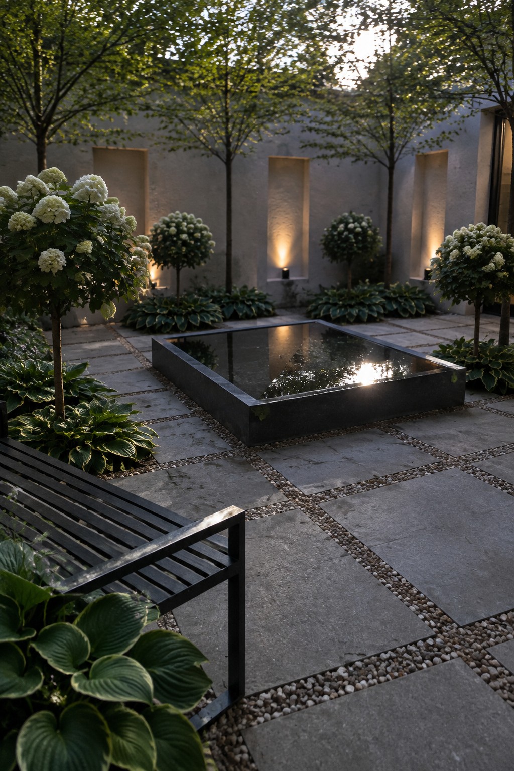 A rectangular reflecting pool sits among stone paving, hostas, flowering hydrangeas, and trees in a walled garden.